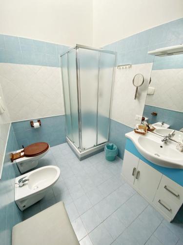 a bathroom with a shower and a toilet and a sink at La Gemma in Naples