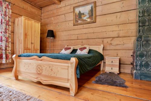 Un dormitorio con una cama en una cabaña de troncos en Dom Tomusik, en Zakopane