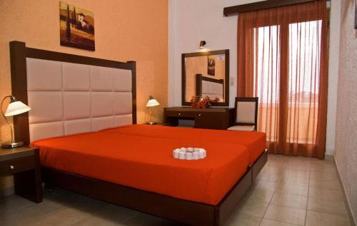a bedroom with a large orange bed and a desk at Hotel Afea in Agia Marina Aegina
