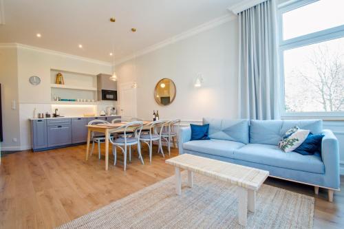 ソポトにあるGrand Apartmentsのリビングルーム(青いソファ、テーブル付)