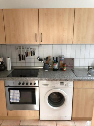 a kitchen with a washing machine and a sink at Zentraler geht es kaum - in königlicher Nachbarschaft! in Ludwigsburg