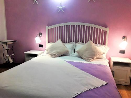 a bedroom with a white bed with purple walls at Stella Marina in Camogli