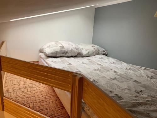 a bed in a bedroom with a wooden frame and a pillow at Apartamenty Plażowa 11 in Darłówko