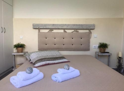 a bedroom with a bed with two towels on it at Kasteli Suite in Poros
