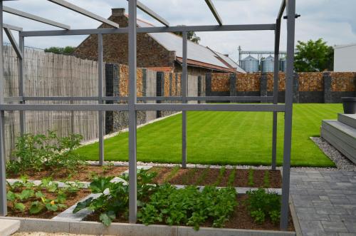a garden with a greenhouse and some plants at Domeček u Prahy in Nupaky