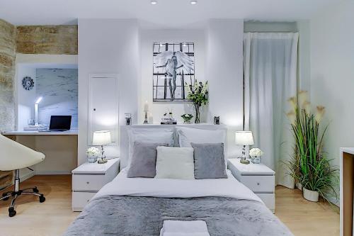 um quarto branco com uma cama e uma secretária em La Maria - Dijon Centre em Dijon
