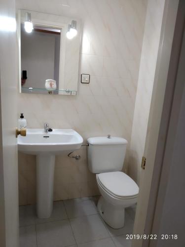 a bathroom with a white toilet and a sink at PEP'S Family House in Empuriabrava
