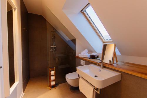 a bathroom with a sink and a toilet with a skylight at Apartmaji štAla in Kranjska Gora