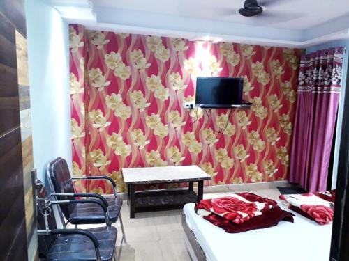 a room with a red wall with flowers on it at Kartar Yatri Niwas in Kānpur