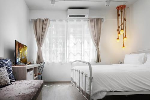 a bedroom with a bed and a window at Hide and Seek Boutique Hometel in Bangkok