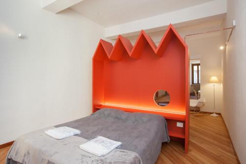 een kamer met een bed met een oranje muur bij Casa Iolanda in Mantova