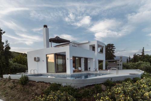 Casa blanca con jardín con piscina en Olive View Villa, en Dhíkella