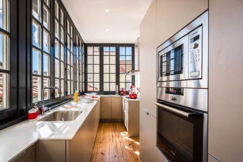 Il comprend une grande cuisine équipée d'un évier et d'un réfrigérateur. dans l'établissement LONDON AVENUE KEYWEEK apartment Biarritz center with balcony and parking, à Biarritz