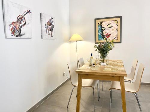 une salle à manger avec une table, des chaises et des peintures dans l'établissement Cozy 2BR Appartment near the Port of Nice, à Nice