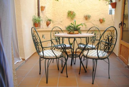 uma mesa com quatro cadeiras e uma mesa com plantas em Casa Rural Casa Puntes em Benifallet
