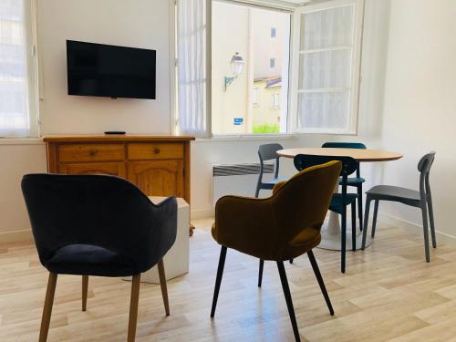 ein Wohnzimmer mit Stühlen und einem Tisch und einem Fernseher in der Unterkunft Artimon Beach appart Les Sables d Olonne in Les Sables-dʼOlonne