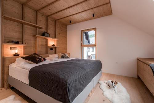 une chambre avec un lit et un chien allongé sur le sol dans l'établissement Apartmaji štAla, à Kranjska Gora