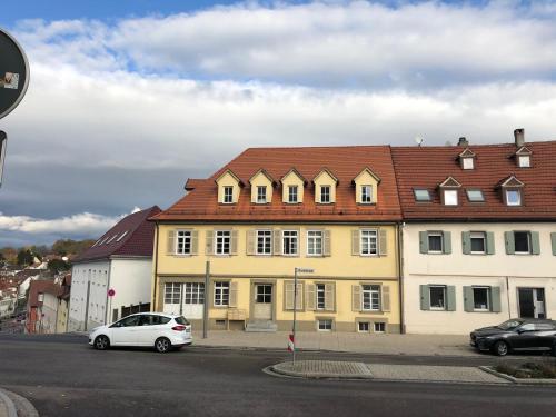 ein weißes Auto, das vor einem gelben Gebäude parkt in der Unterkunft Zentraler geht es kaum - in königlicher Nachbarschaft! in Ludwigsburg