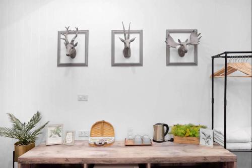 a room with a wooden table with antlers on the wall at Hide and Seek Boutique Hometel in Bangkok