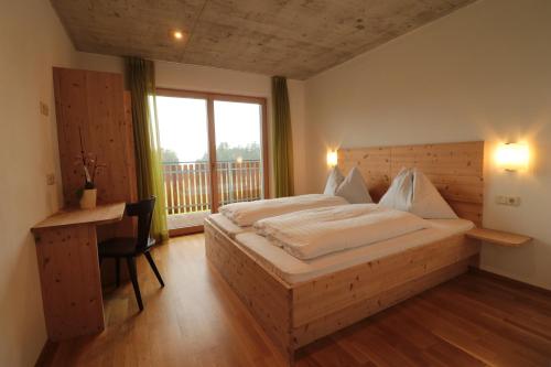 ロデンゴにあるPension Steigerhofのベッドルーム1室(ベッド1台、デスク、窓付)