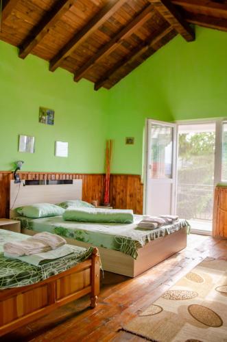 a green room with three beds in it at Danailovi Guest House in Sapareva Banya