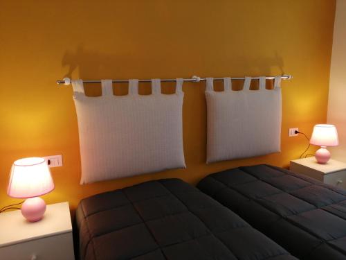 sypialnia z łóżkiem i 2 lampkami na stołach w obiekcie Appartamento al sole w mieście Pieve di Cadore