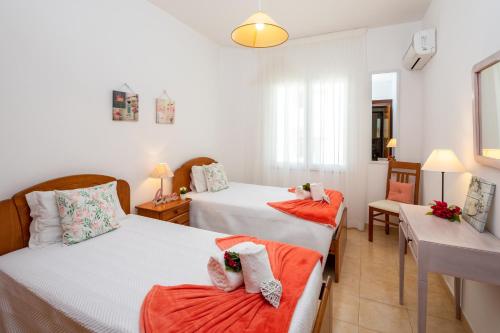 a bedroom with two beds and a table at Apartamento Pé na Areia, Armação de Pêra in Armação de Pêra