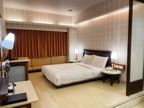 a hotel room with a bed and a phone in it at 種子商旅 in Kaohsiung