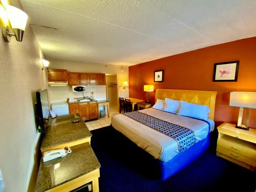 a hotel room with a bed and a kitchen at Breeze Inn & Suites, Virginia Beach in Virginia Beach