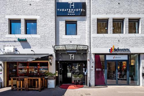 a white brick building with two store fronts at Theaterhotel Venlo in Venlo