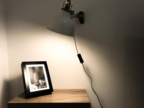 a light on a wall with a picture on a table at VIATOREM Suites in Torre dell'Orso