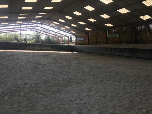 an inside view of a large arena with a large horse at camping de warincthun in Audinghen