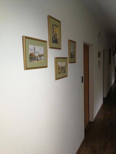 a hallway with three pictures on a white wall at Levanda Panzió in Kópháza