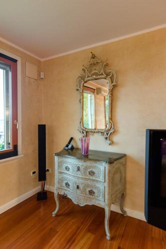 a room with a dresser with a mirror on the wall at Lake Front Luxury Apartment in Sirmione