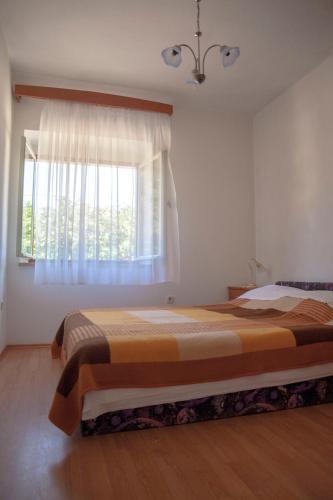 a bedroom with a large bed and a window at Apartment Curri in Pučišća