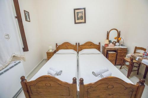 a bedroom with a wooden bed with white sheets at Iosiphis Stonebuilt House in Pano Lefkara