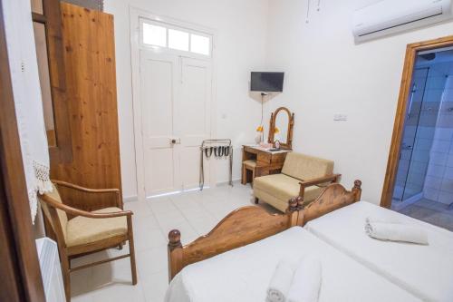 a bedroom with a bed and a chair and a desk at Iosiphis Stonebuilt House in Pano Lefkara