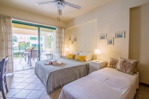 a bedroom with two beds and a balcony at Aqua Vista Casa at Xylokastro in Xylokastron
