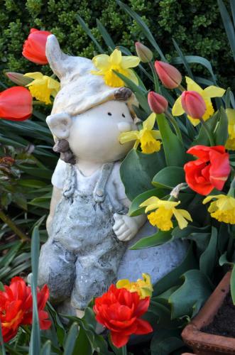 a statue of a teddy bear in a bed of flowers at Zimmervermietung Gröberhof in Schenna
