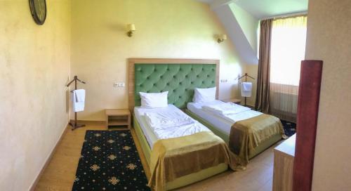 フメリヌィーツィクィイにあるPivdenna Bramaのベッド2台と窓が備わるホテルルームです。