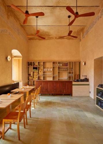 una cucina con tavoli e sedie in legno in una stanza di Hotel Escondido Oaxaca, a Member of Design Hotels a Città di Oaxaca