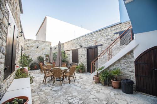 un patio al aire libre con mesa y sillas en Iosiphis Stonebuilt House, en Pano Lefkara
