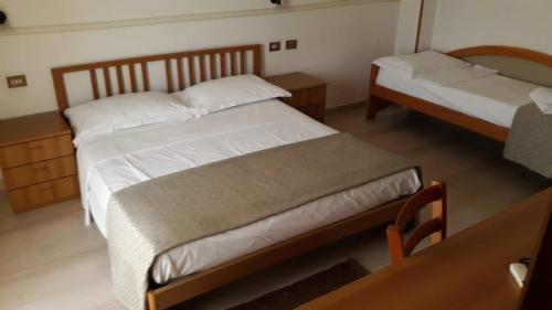 a bedroom with two beds and a table and a mirror at Locanda Ermes in Capaccio-Paestum