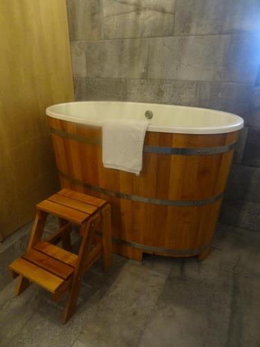 eine Holzbadewanne mit einem Stuhl im Bad in der Unterkunft Apartmá s vlastní saunou in Lipník nad Bečvou