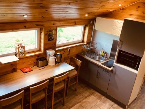 une cuisine avec un comptoir et un réfrigérateur dans l'établissement le chalet de la ferme du tertre, à Villers-au-Tertre