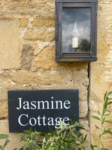 a sign on the side of a building with a window at Jasmine Cottage, Upper Slaughter, Cotswolds in Cheltenham