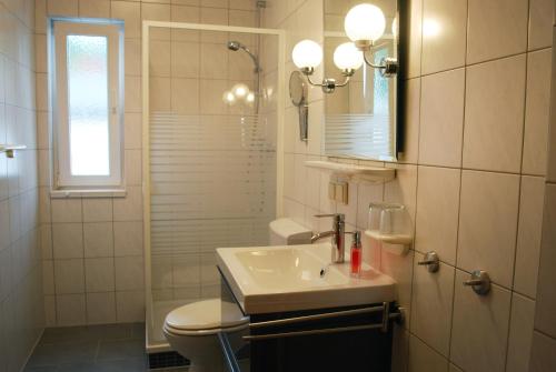 a bathroom with a sink and a toilet and a shower at Villa Anna in Ostseebad Sellin