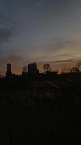 a sunset in a field with a gazebo at Vár-Liget Vendégház in Kisnána