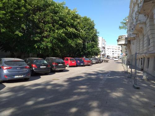 a row of cars parked on the side of a street at Apartament Promenada, 3 camere, langa Cazino, Faleza, Acvariu, Port Tomis, Plaja, Piata Ovidiu in Constanţa