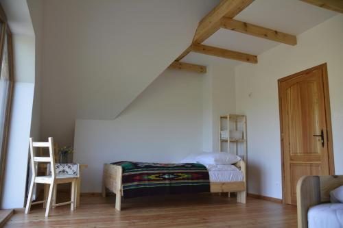 a room with a bed and a chair and a table at Michniowiec 6 in Czarna